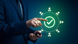 © Shahid - Businessman interacting with glowing green checkmark interface on smartphone