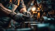 © irawan - Close-up of a mechanic working on machinery in a dimly lit workshop environment.
