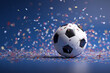 © Tohamina - A soccer ball sits on a field covered in colorful confetti against a blue background