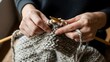 © Matt - A person skillfully knitting with yarn and needles in a quiet moment