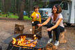 © unai - Tourists roasting marshmallows over campfire in banff national park