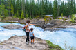 © unai - Mother and son admiring bow river natural bridge in banff national park