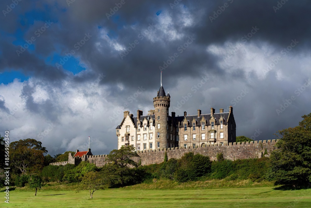 Majestic historic stone castle on a green hill beneath dramatic stormy ...