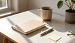 © Hussein - Workspace flat lay with notebook, pen, coffee mug, eyeglasses, and small potted plant on a white marble desk.