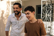 © kleberpicui - Father places his hand on his teenage son’s shoulder while talking outdoors, expressing emotional support, trust, empathy, and a strong parent-child bond focused on wellbeing and mental health