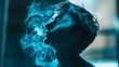 © Crafted - A young man exhales a cloud of blue smoke, creating a mysterious and artistic portrait. His face is partially obscured by the smoke, adding to the sense of intrigue.