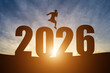 © Thinapob - Happy New Year Numbers 2026, Silhouette a man handsome jumping feels happy moving early morning sunrise over the horizon background, Health and Happy new year concept.