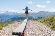 © Elena Medoks - Young woman balancing on wooden beam in the alps mountains