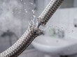 © Aurora Aesthetics - Burst braided stainless steel water hose plumbing emergency repair maintenance house damage accident flood insurance claim plumber service professional background