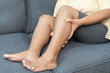 © KMPZZZ - Muscle pain or leg pain, suffer asian aged woman, senior massaging brawn leg calf muscle cramps or spasm, older trauma from inflammation of tendon at calves while sitting on sofa. Health care concept.