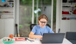 © Volodymyr - Child study at home with laptop and books. Kid learning in a cozy home classroom. Kid study at classroom. Online learning. Kid thinking concept. Child study at home. Boy doing school homework.