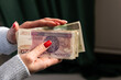 © workszop - kobieta trzyma w rękach plik banknotów. Płać gotówką