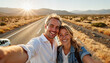 © Elenba - Happy couple taking a selfie on a scenic road at sunset
