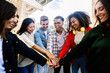 © Xavier Lorenzo - Happy multiracial friends showing unity by holding hands, enjoying time together in the city. Friendship and bonding concept.