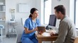 © Muhammad - Smiling female nurse in blue scrubs consulting male patient with digital tablet in clinic