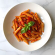 © Phatcharee - Italian Penne Pasta with Spicy Tomato Sauce and Fresh Basil on Marble