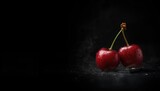 Two organic wild cherries on a dark backdrop, suitable for editorial header background, fresh fruit focus