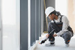 © Serhii - Construction worker sealing window frame in building under construction