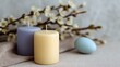 © progressman - Two candles are lit and placed on a table next to a white egg