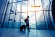 © Song_about_summer - travel by flight, silhouette of passenger in airport, woman walking with luggage in airport, airplane flying in the sky on background