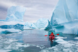 kayaking in Antarctica, man paddling on kayak between icebergs and ice, adventure expedition travel