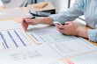 © Teelapon - Business professional using a smartphone while reviewing financial documents on a desk. Concept of accounting, financial analysis, online banking, mobile technology, and business management.