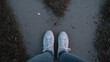 © Broccolini - standing on a dirt path in white sneakers, first person view of casual walking, quiet moment before taking a step