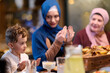 © .shock - Muslim family enjoying iftar together in a restaurant with Ramadan decorations