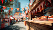 © Sabana - A wooden food stand at an outdoor festival or fair offering hot dogs on red and white checkered paper with colorful triangular flags hanging above