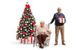 © Ljupco Smokovski - Elderly man and woman with a gift box next to a Christmas tree