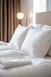 © Happy - Close up of soft white pillows and duvet on a bed in a bright bedroom