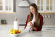 © New Africa - Woman wiping lemon with paper towel at white marble table in kitchen
