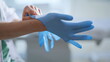 © stockbusters - Doctor hands putting gloves preparing to medical procedures at cabinet closeup