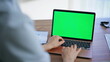 © stockbusters - Doctor texting green screen laptop in healthcare facility closeup. Woman typing