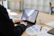 © David - Asian Business woman using calculator and tablet laptop for doing math finance on an office desk, tax, report, accounting, statistics, and analytical research concept
