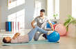 © Studio Romantic - Caucasian woman engages in a rehabilitation fitness session at the sport gym with personal trainer. Utilizing a fitness ball for exercises, doing workout with assistance and advice of a coach.