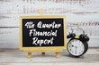 © may1985 - 4th Quarter Financial Reporttext written on blackboard with alarm clock on wooden background