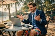 © Loginova - Businessman in suit jacket and colorful shorts working on laptop at beach caf√©, funny remote work and work-life balance concept.