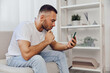 © SHOTPRIME STUDIO - Thoughtful man browsing on smartphone, dressed casually, showing focused expression, surrounded by modern interior decor. Inspired by minimalist trends in lifestyle.