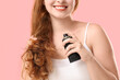 © Pixel-Shot - Young redhead woman applying hair spray on pink background, closeup