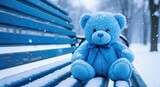 Blue teddy bear on a blue bench under the snow - Blue Monday concept