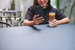 © Farknot Architect - Closeup image of a woman holding and using mobile phone while drinking coffee in cafe