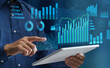 © tadamichi - Data analysis and business intelligence. Visualization of KPIs. Graphs and statistical reports. Businessperson using tablet computer to look at analytics dashboard.