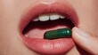 © faki - Close-up of open mouth, holding a green capsule ready to ingest with pink lips