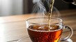 © dwi - Steaming hot tea being poured slowly.