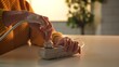 © kinomaster - Close up of hands inserting a power plug into a surge protector on a table, with a blurred background.