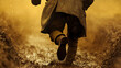 © photo for everything - A figure clad in worn clothing sprints through a muddy terrain, their form captured from a low angle that emphasizes the struggle and determination in the face of adversity.