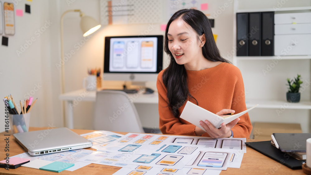 Professional UX UI designer working at a home office, reviewing mobile ...