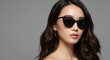 © Elitemedia - Stylish young woman with dark hair wearing trendy black sunglasses against a neutral background, showcasing modern fashion accessory