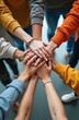 © miss irine - Diverse group of young adults place hands together in office. People show unity strength and support for charity. Teamwork in organization collaboration for common goal.